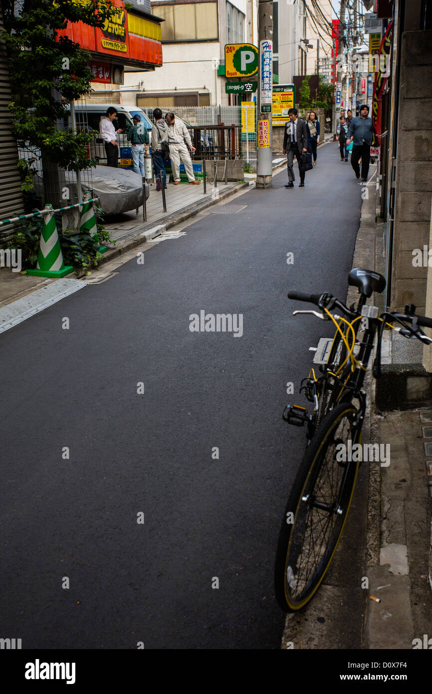 Una moto che si trova all'ingresso di una strada posteriore a Tokyo Foto Stock