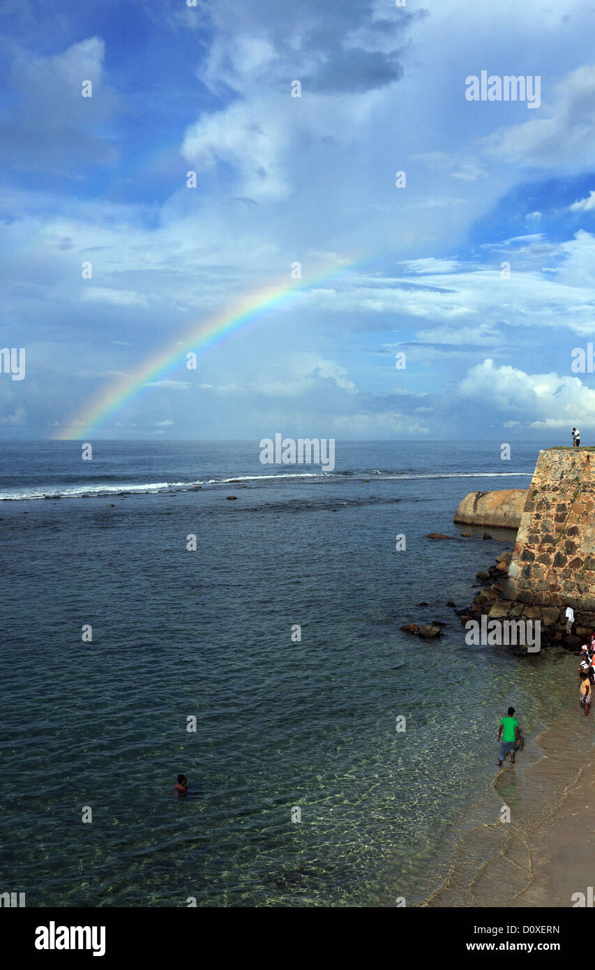 Persone per godersi la spiaggia sulla parete esterna del Forte di Galle. Foto Stock