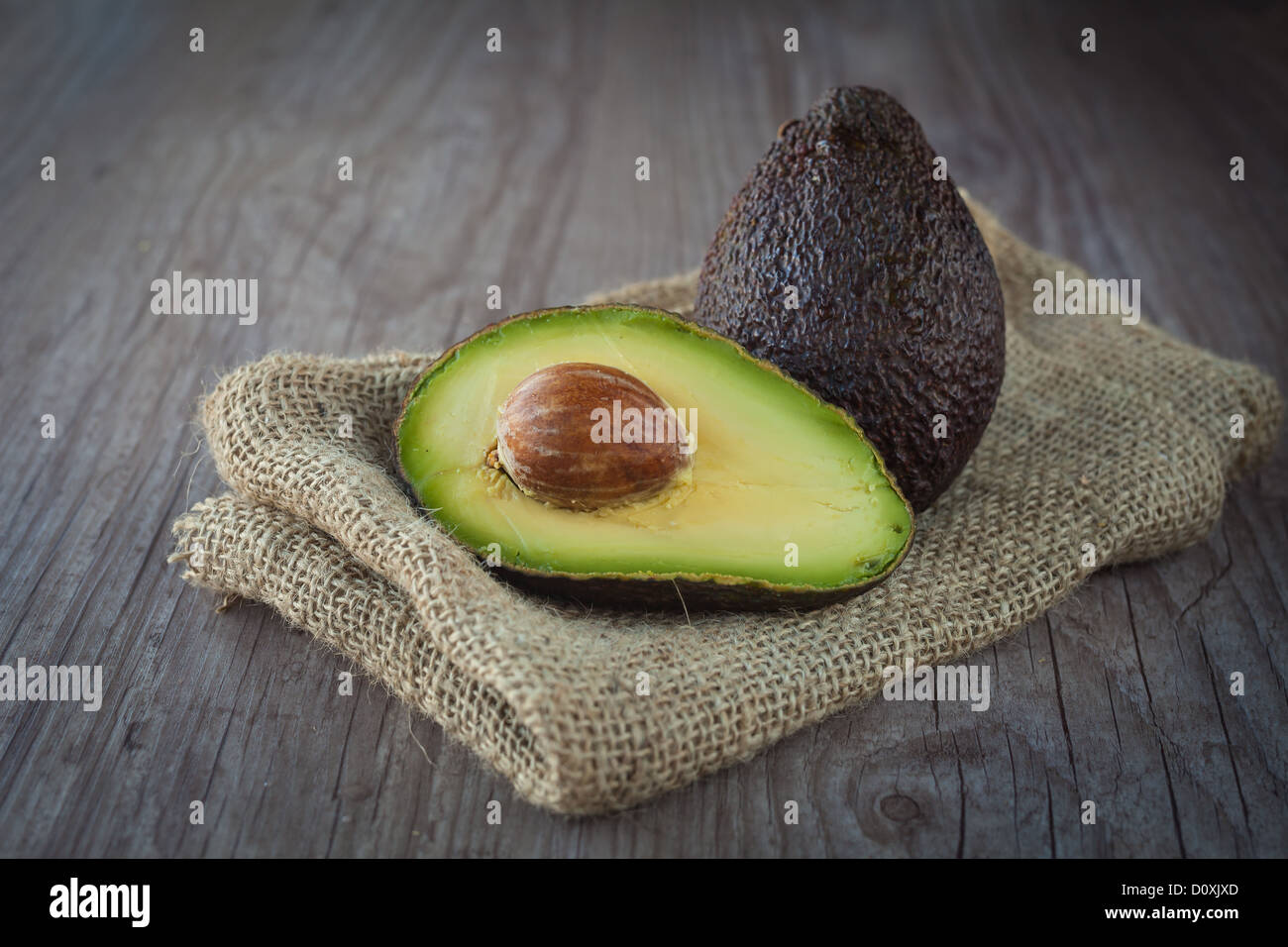 Fresco frutto di avocado su un sfondo di legno Foto Stock