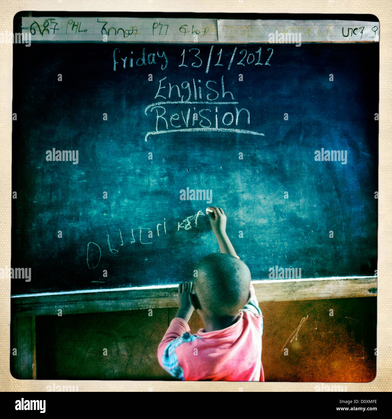 Vista posteriore di Rasta Kid scrivere sulla lavagna per revisione inglese In Shashemene Scuola giamaicano, Regione Oromia, Etiopia Foto Stock