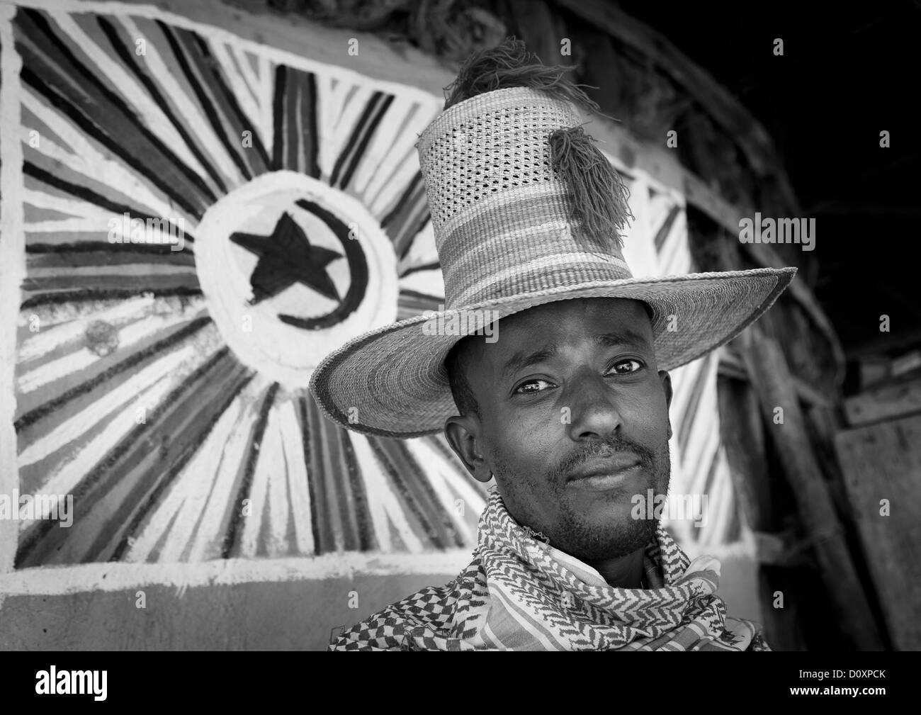 Ritratto di un uomo musulmano con alte Hat dentro la sua Tukul, Alaba, Etiopia Foto Stock