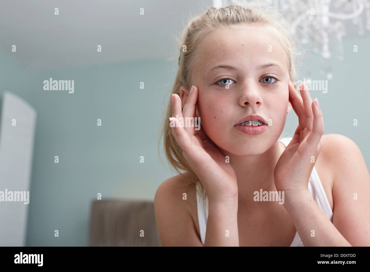 Ragazza adolescente toccando il suo volto Foto Stock