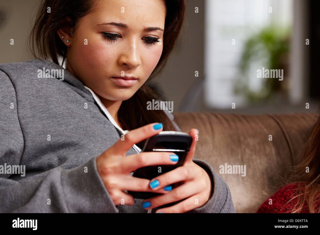 Ragazza adolescente guardando al cellulare Foto Stock