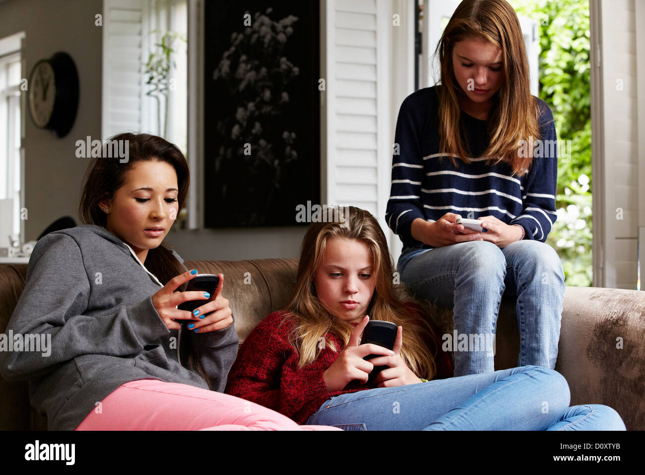Le ragazze adolescenti utilizzando i telefoni cellulari Foto Stock