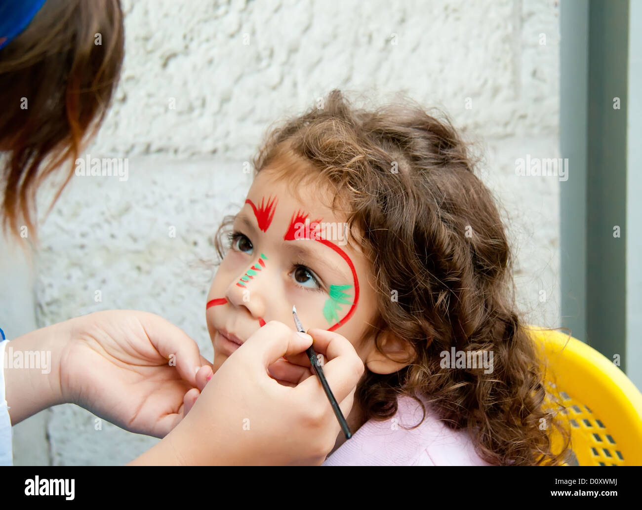 Bambina con vernice faccia cercando Foto Stock