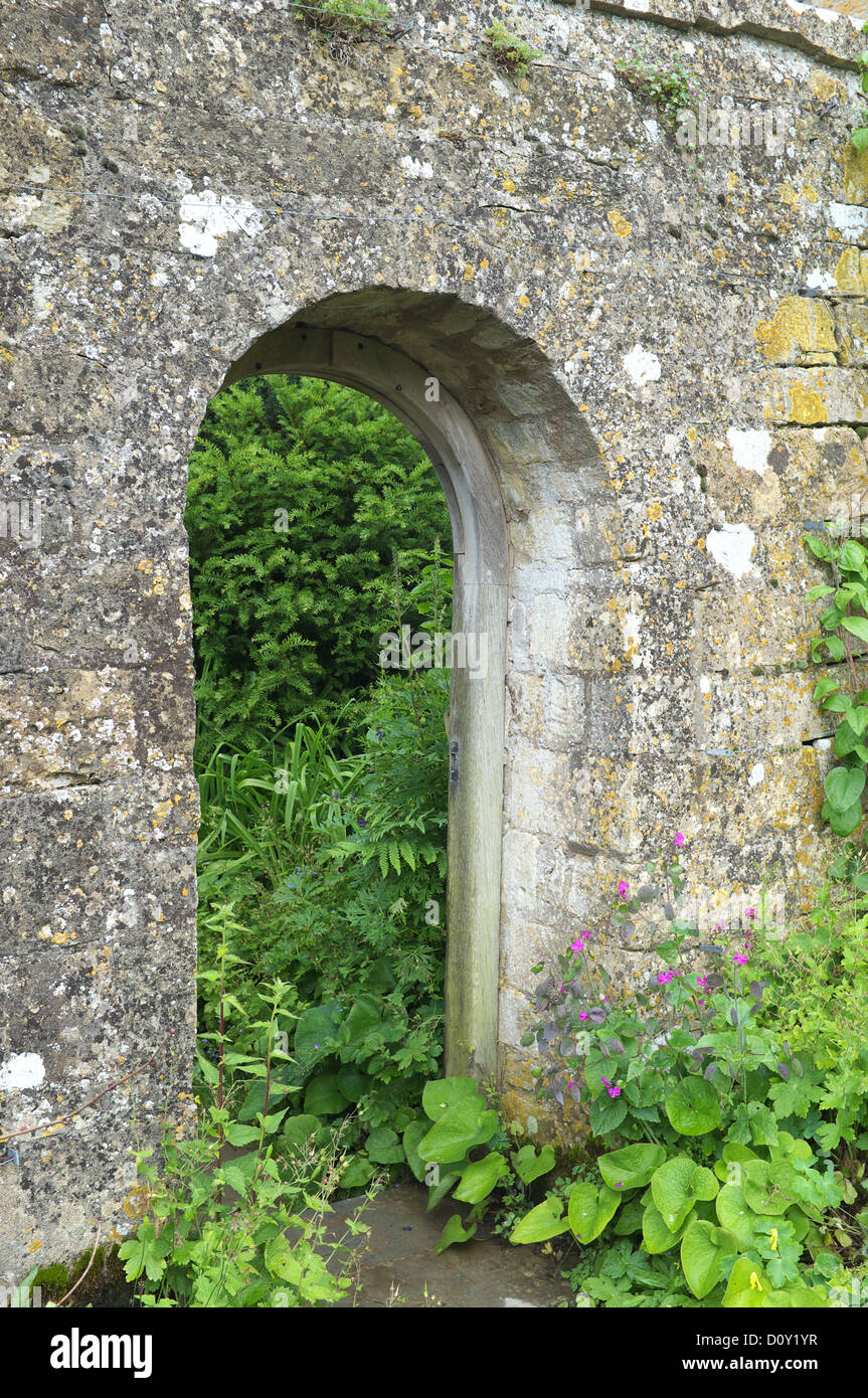 Stone ingresso ad arco in un giardino murato, England, Regno Unito Foto Stock