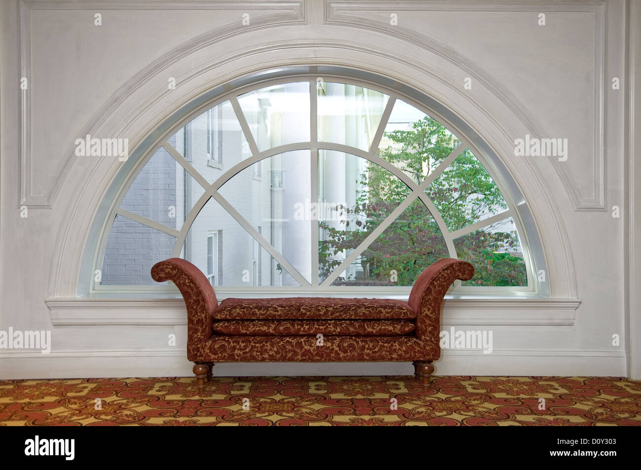 Dormeuse chaise lounge nella parte anteriore della finestra ad arco, Hall Hotel Foto Stock
