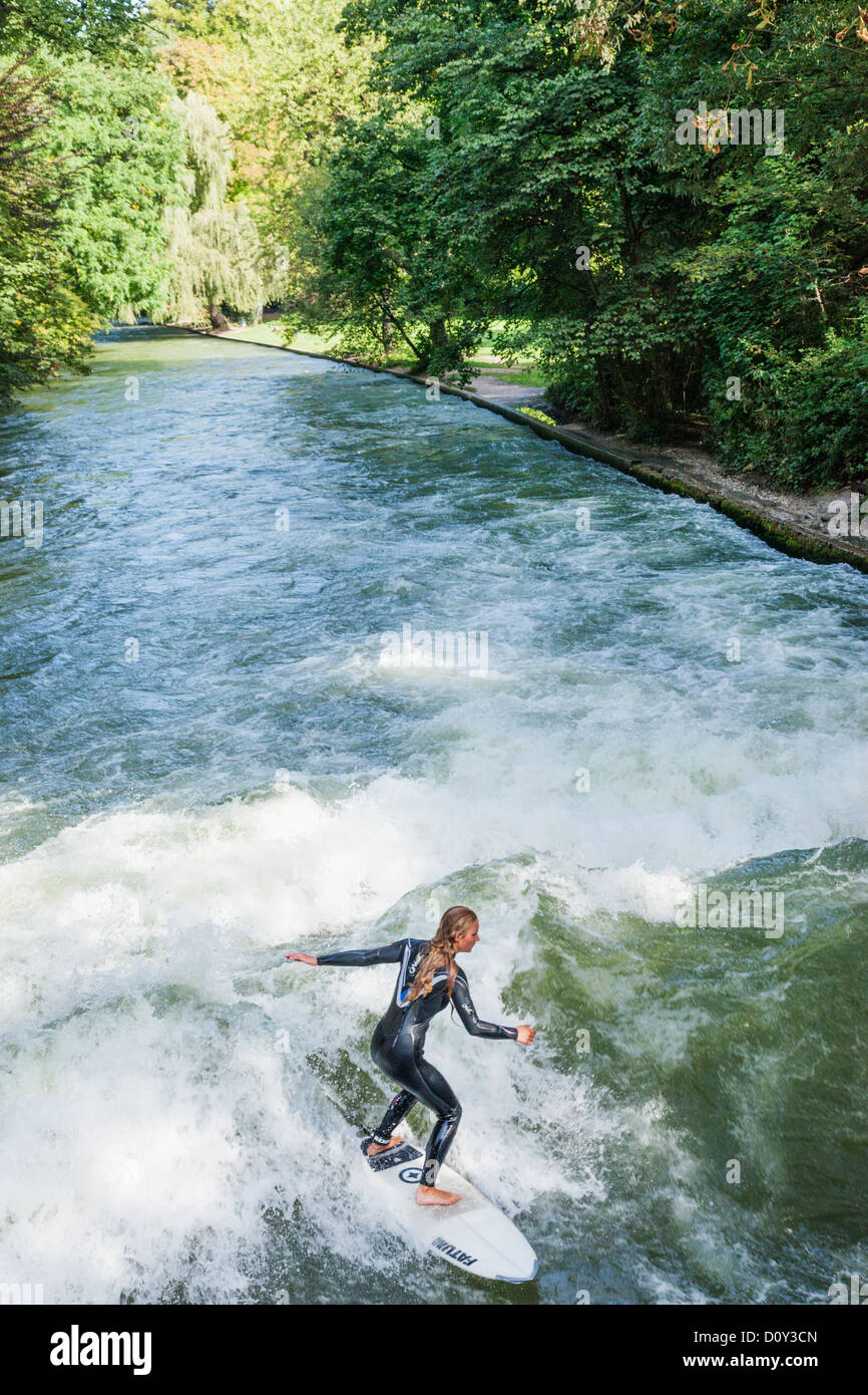 In Germania, in Baviera, Monaco di Baviera, il Giardino Inglese surfista femmina sull'onda Eisbach Foto Stock