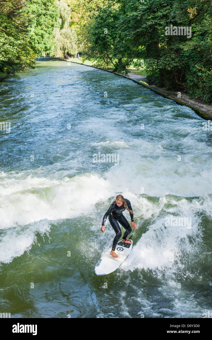In Germania, in Baviera, Monaco di Baviera, il Giardino Inglese surfista femmina sull'onda Eisbach Foto Stock