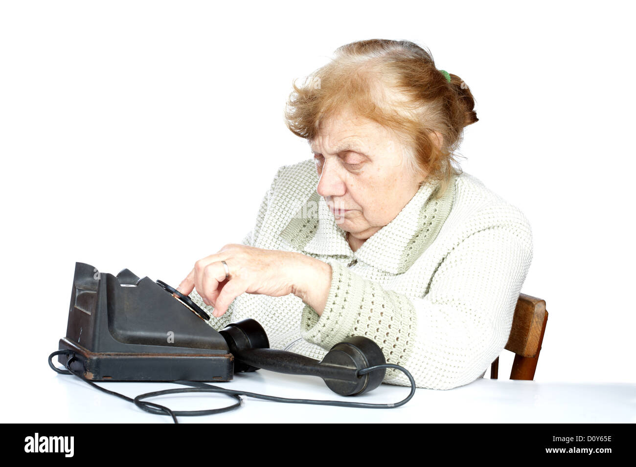 Il vecchio donna compone il numero di telefono Foto Stock
