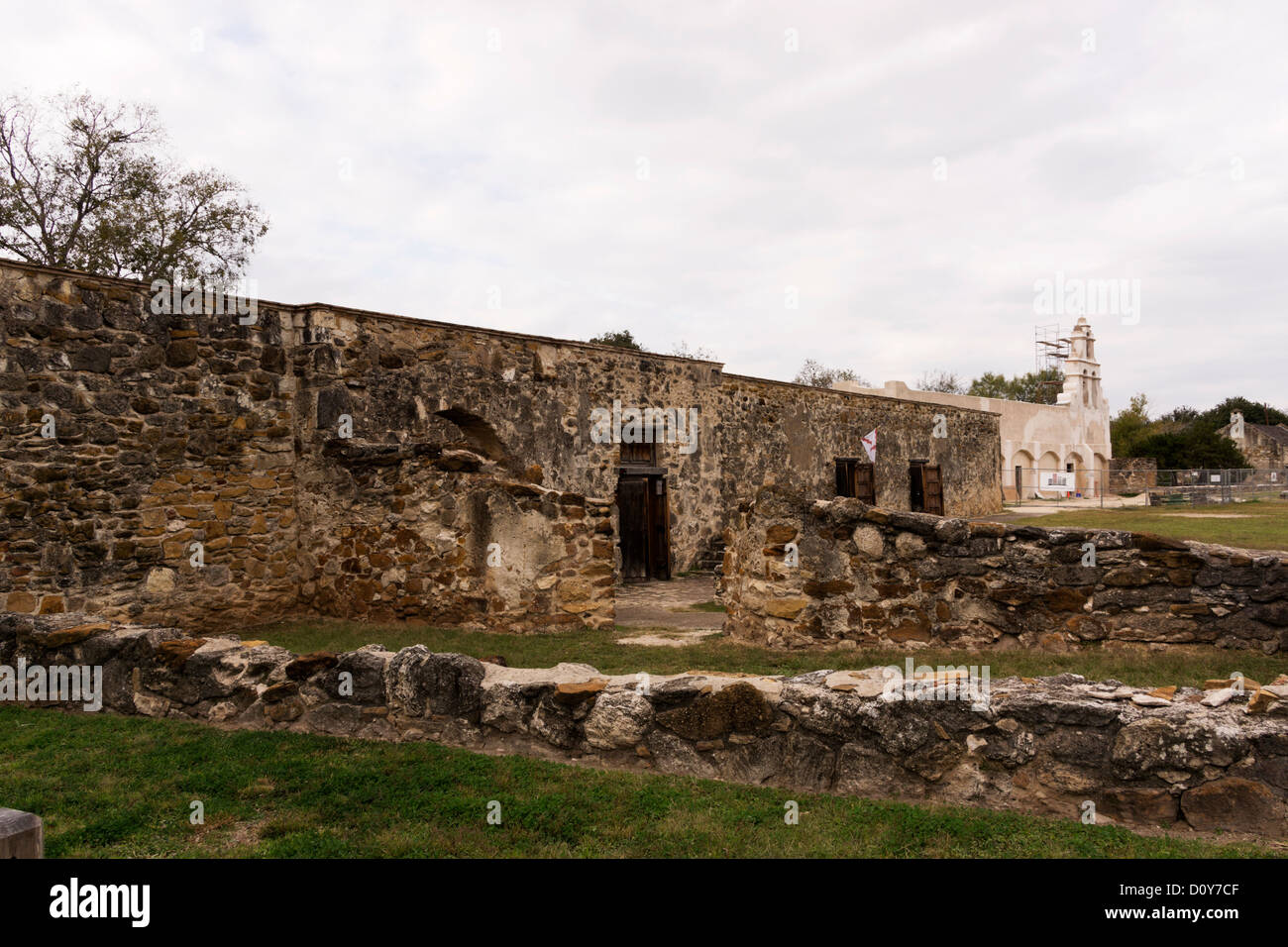 I muri di pietra e le fondazioni presso la missione di San Juan Capistrano con la chiesa in background. Foto Stock