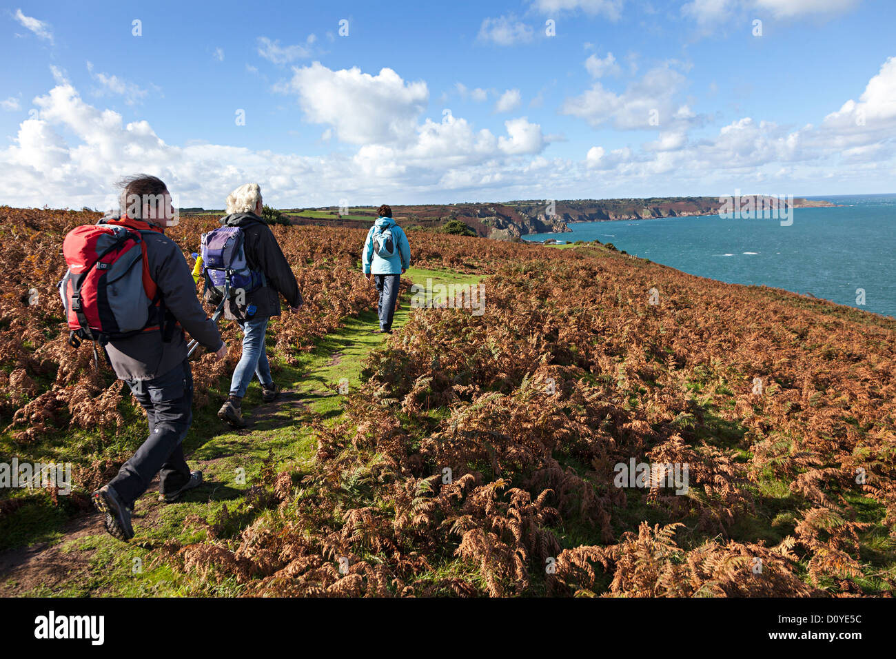 Tre persone a piedi il sentiero della scogliera sulla costa nord di Jersey, Isole del Canale, REGNO UNITO Foto Stock