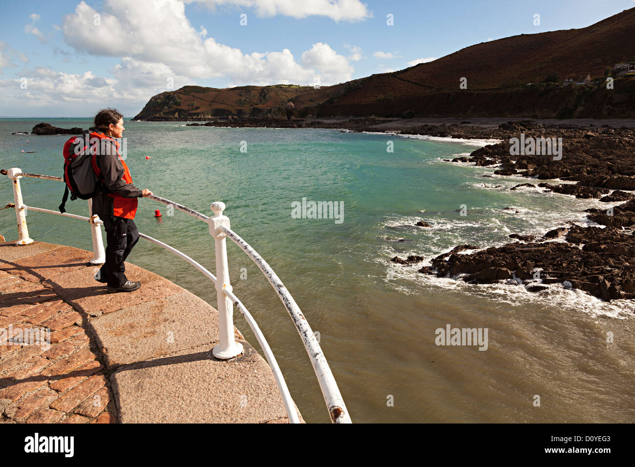Persona in piedi sulla parete del porto guardando il mare, Bonne Nuit, Jersey costa del nord, Isole del Canale, REGNO UNITO Foto Stock