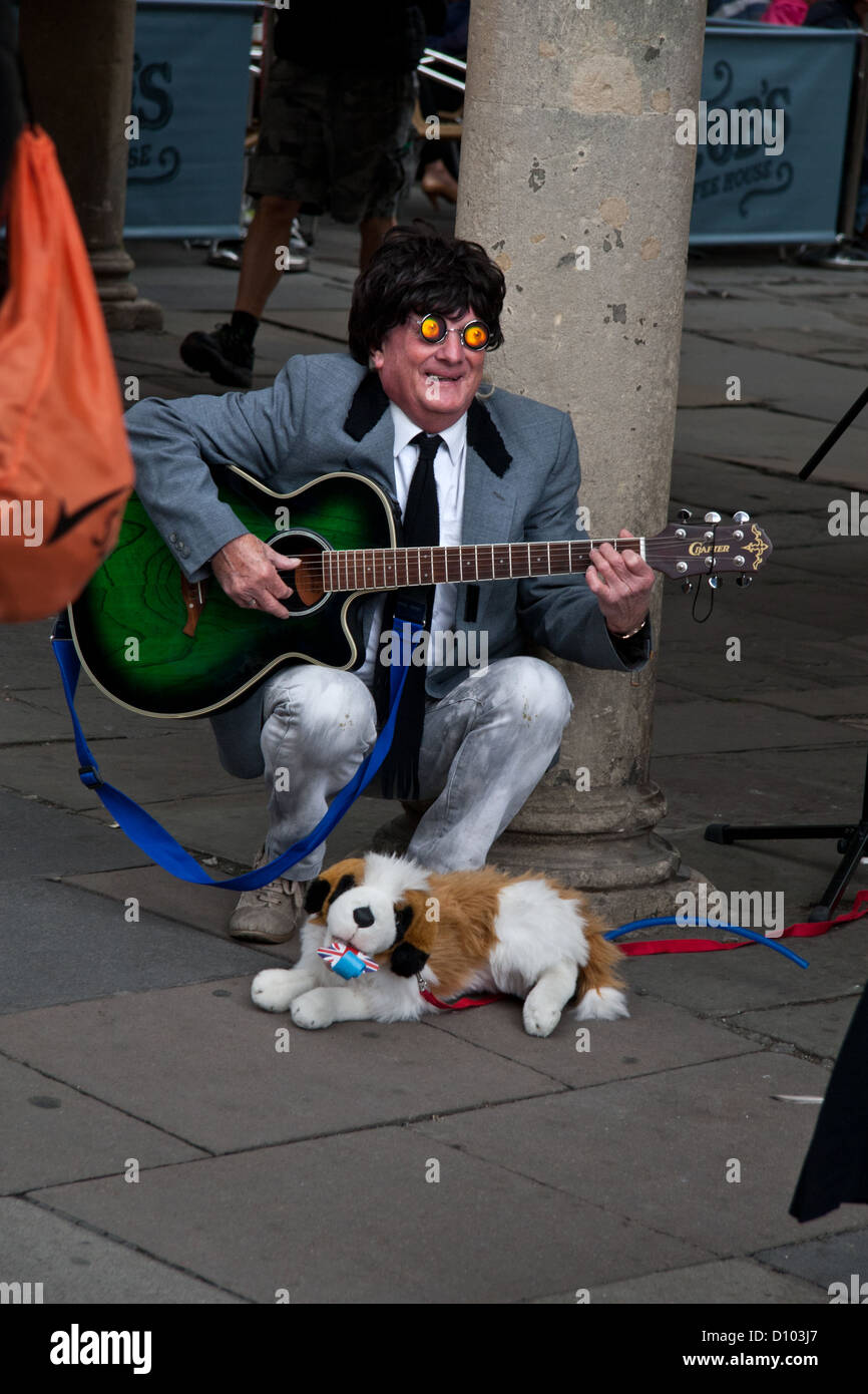 Il chitarrista busker in costume esotico con cane giocattolo: Bath Regno Unito Foto Stock