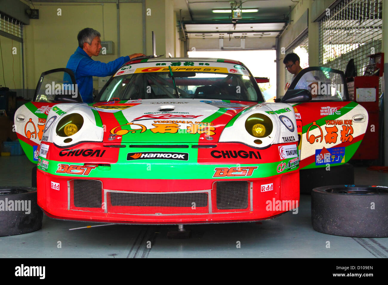 Hankook team di lavoro meccanico sulla loro corsa auto nel garage sul circuito di Sepang. Foto Stock