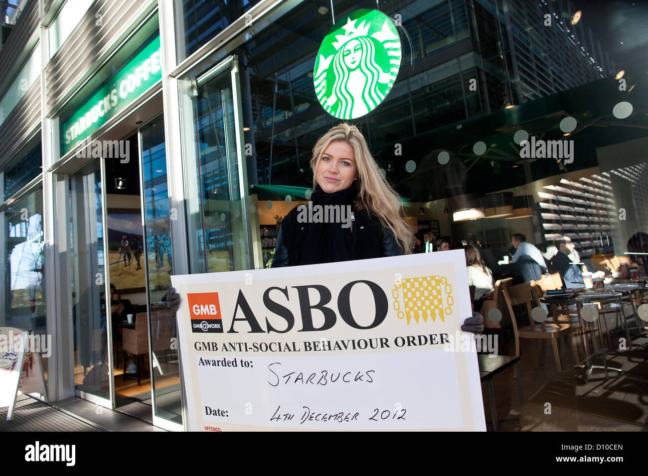 Starbucks Coffee. La Chiswick High Road, Londra, Regno Unito. Il 4 dicembre 2012. GMB unione stati Lauren Tinney dimostrando al di fuori degli uffici di Starbucks in Chiswick High Road su denunce che la ditta di caffè non paga il suo personale i salari. Foto Stock