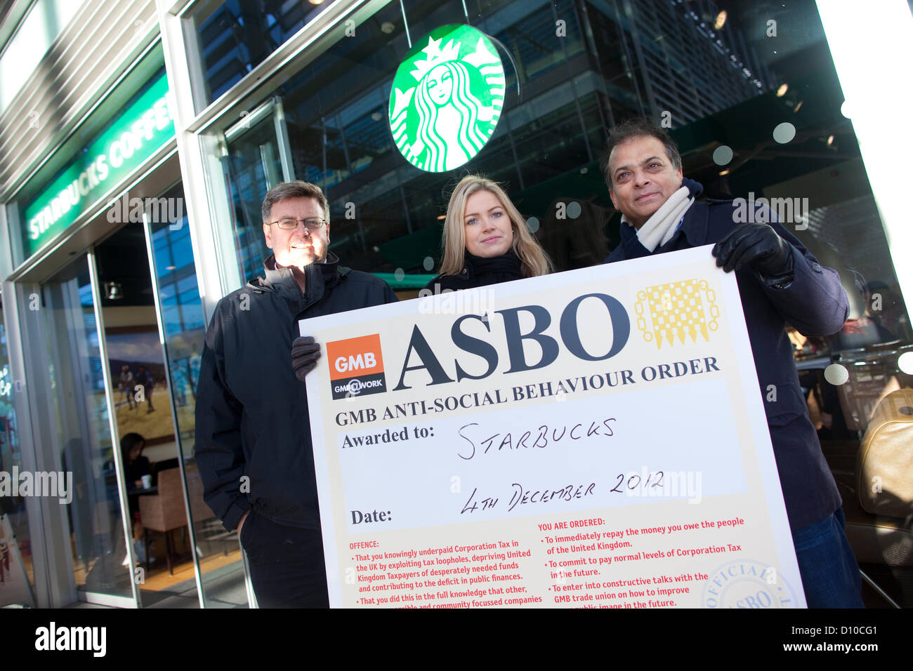 Starbucks Coffee. La Chiswick High Road, Londra, Regno Unito. Il 4 dicembre 2012. GMB europea membri (l-r) Martin Smith, Lauren Tinney e Tahir Bhatti dimostrando al di fuori degli uffici di Starbucks in Chiswick High Road su denunce che la ditta di caffè non paga il suo personale i salari. Foto Stock