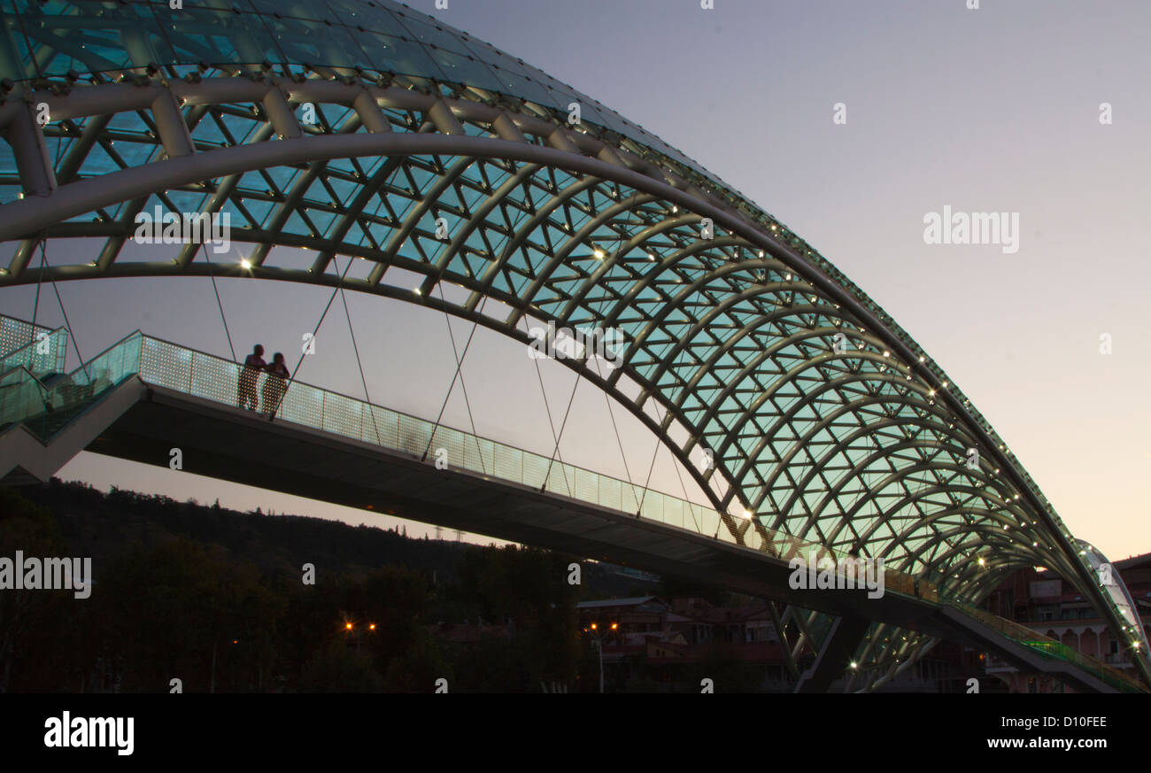 Il Ponte della Pace spanning fiume Mtkvari a Tbilisi dopo il tramonto Foto Stock