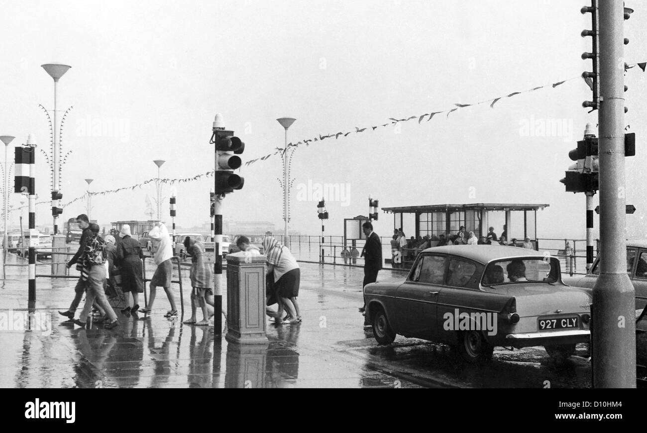 I vacanzieri umido sul lungomare di Hastings nel 1966. Foto Stock