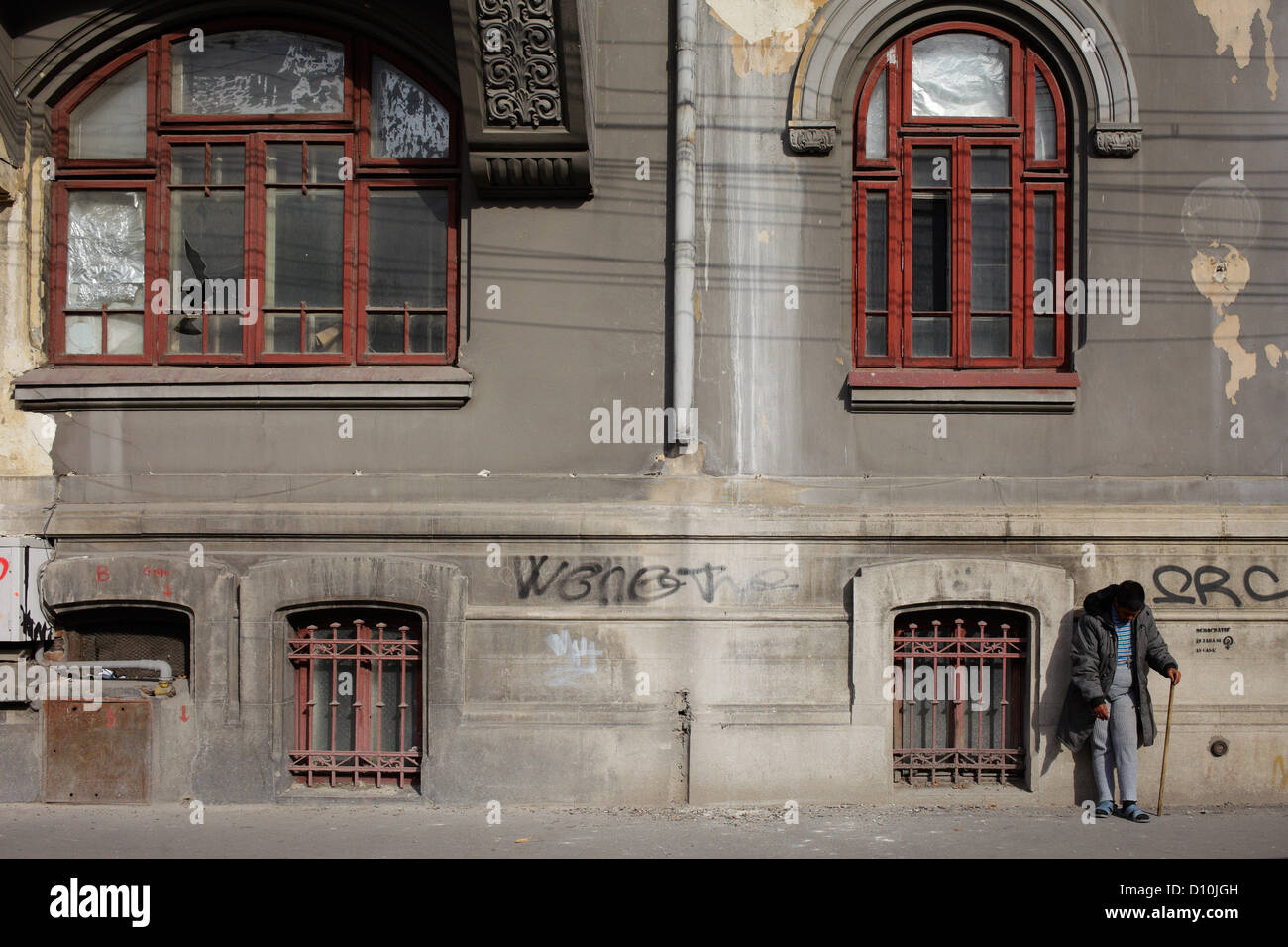 Bucarest, Romania, un uomo si appoggia contro un vecchio edificio Foto Stock