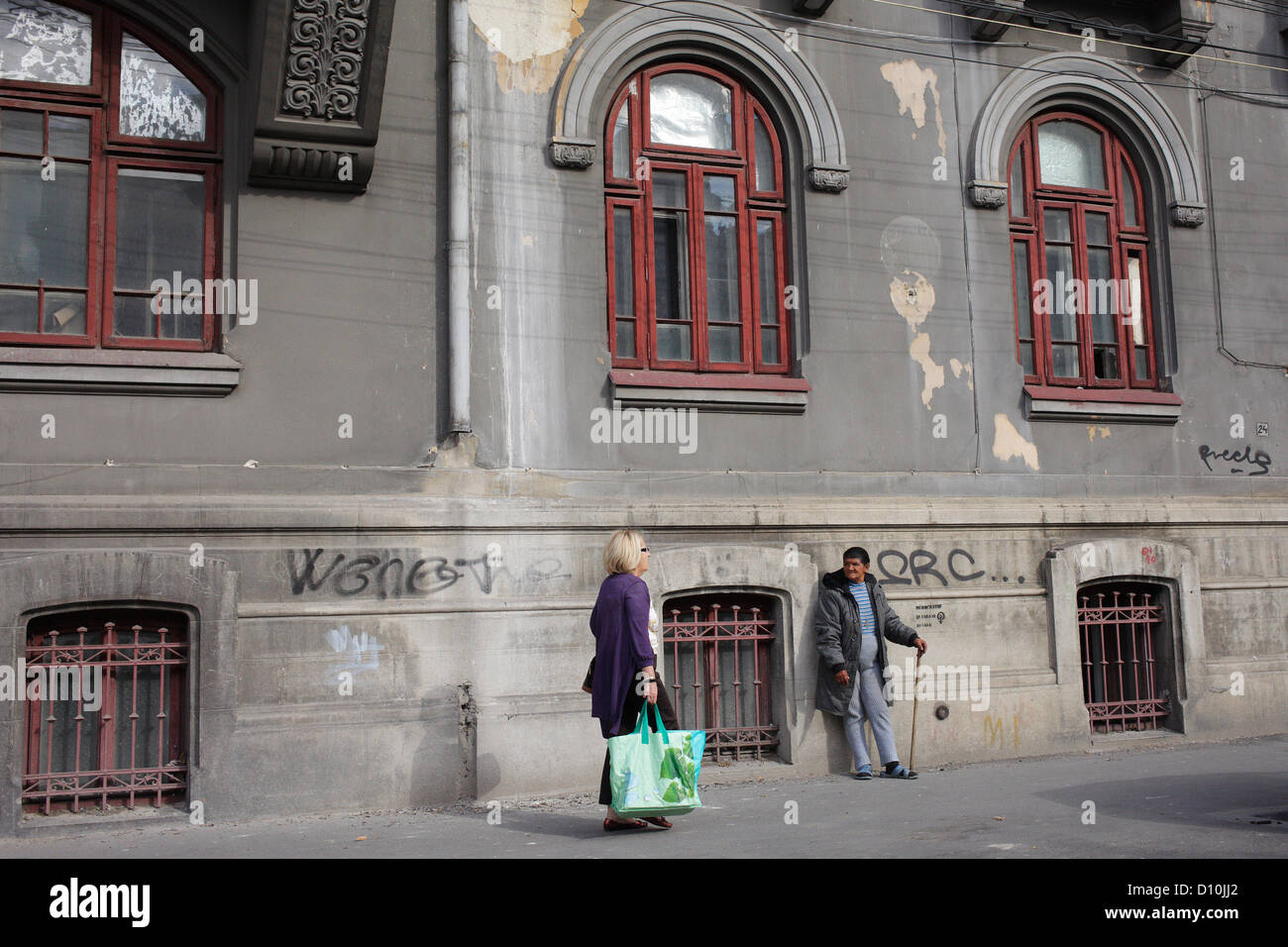 Bucarest, Romania, un uomo si appoggia contro un vecchio edificio Foto Stock