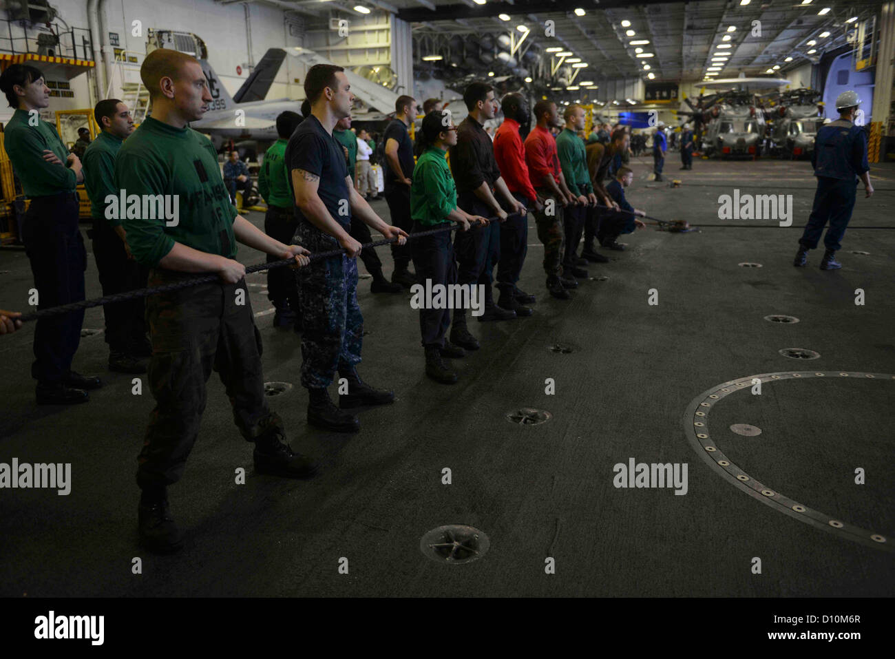 Standby marinai su una linea di messenger in hangar bay due durante un rifornimento in mare con la forza militare di comando Sealift fast combattere la nave appoggio USNS Ponte (T-AOE 10) a bordo della portaerei USS John C. Stennis (CVN 74). John C. Stennis è distribuito da Foto Stock