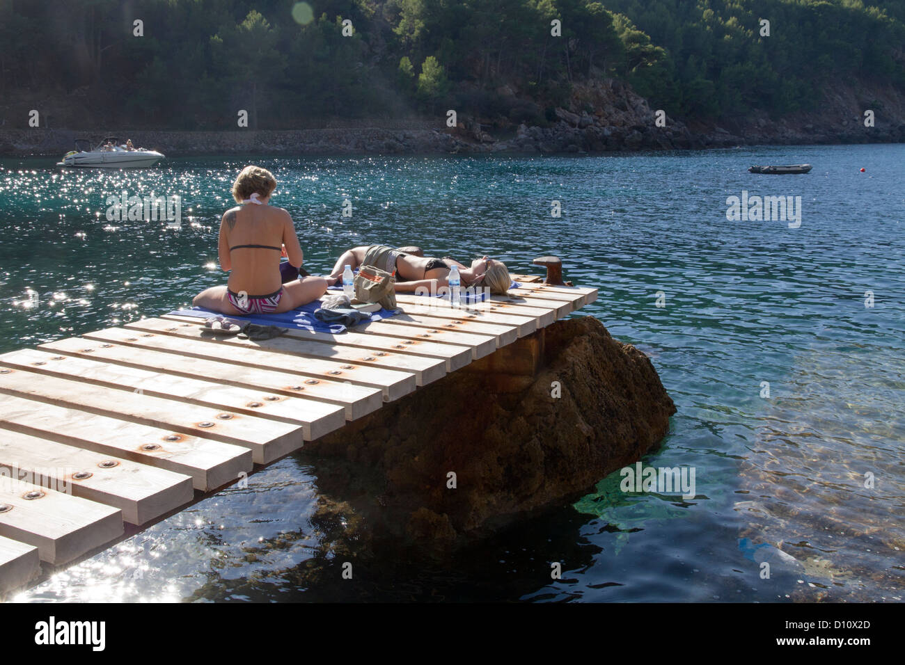 Due donne i turisti a prendere il sole sul molo maiorca isole baleari Spagna Europa Mediterraneo mare Foto Stock