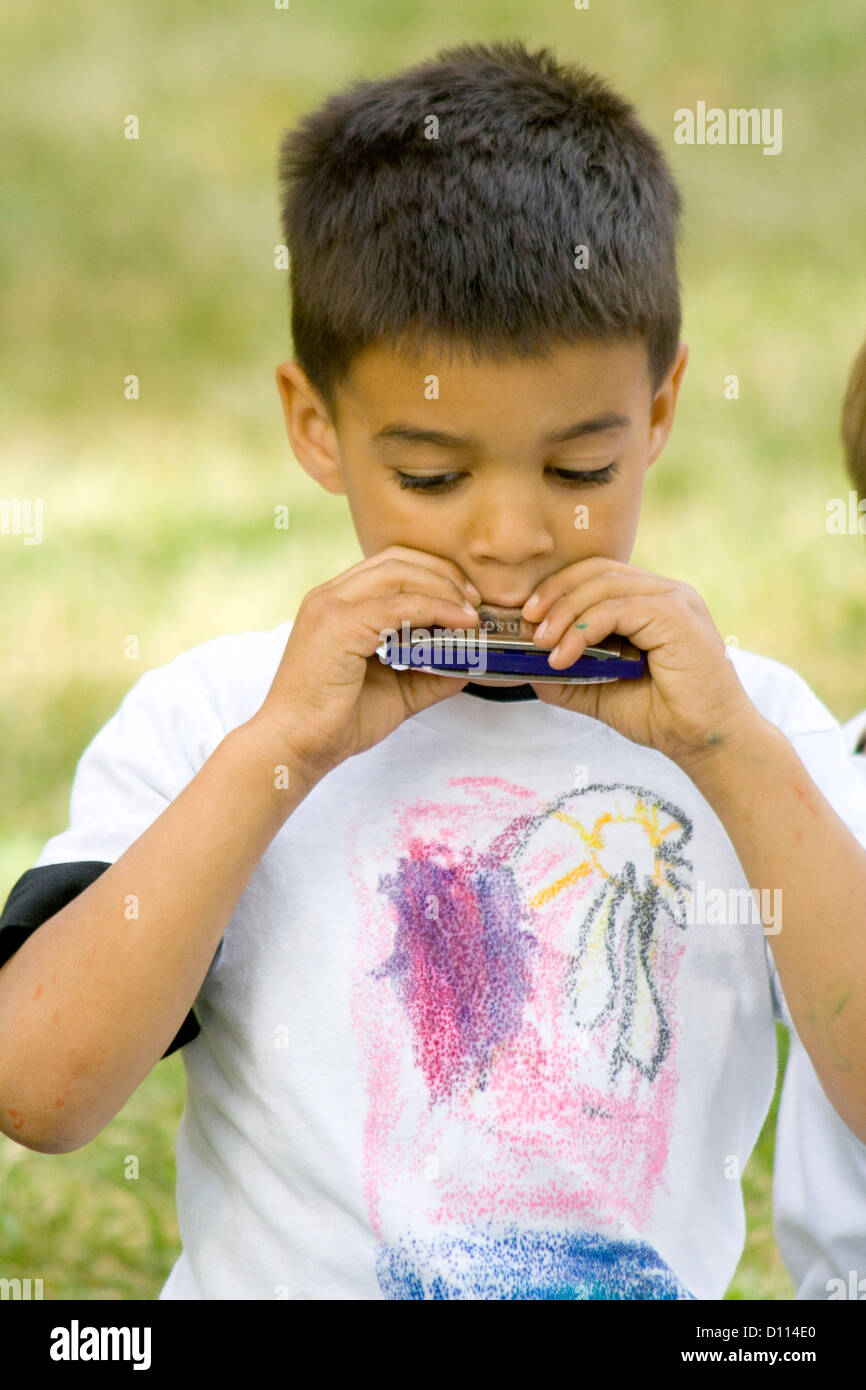 African American boy otto anni giocando harmonica durante al di fuori classe Presentazione. St Paul Minnesota MN USA Foto Stock