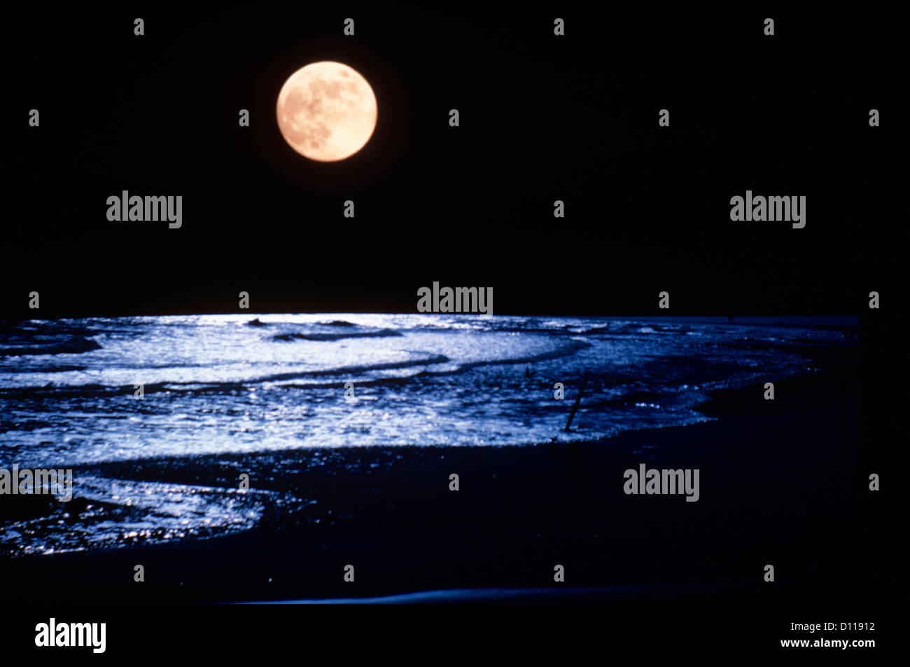 Luna piena oltre oceano onde Foto Stock