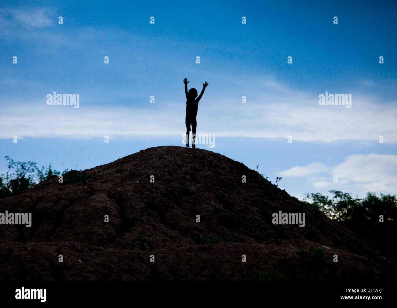 Banna tribù Kid saltando su una collina, Valle dell'Omo, Etiopia Foto Stock