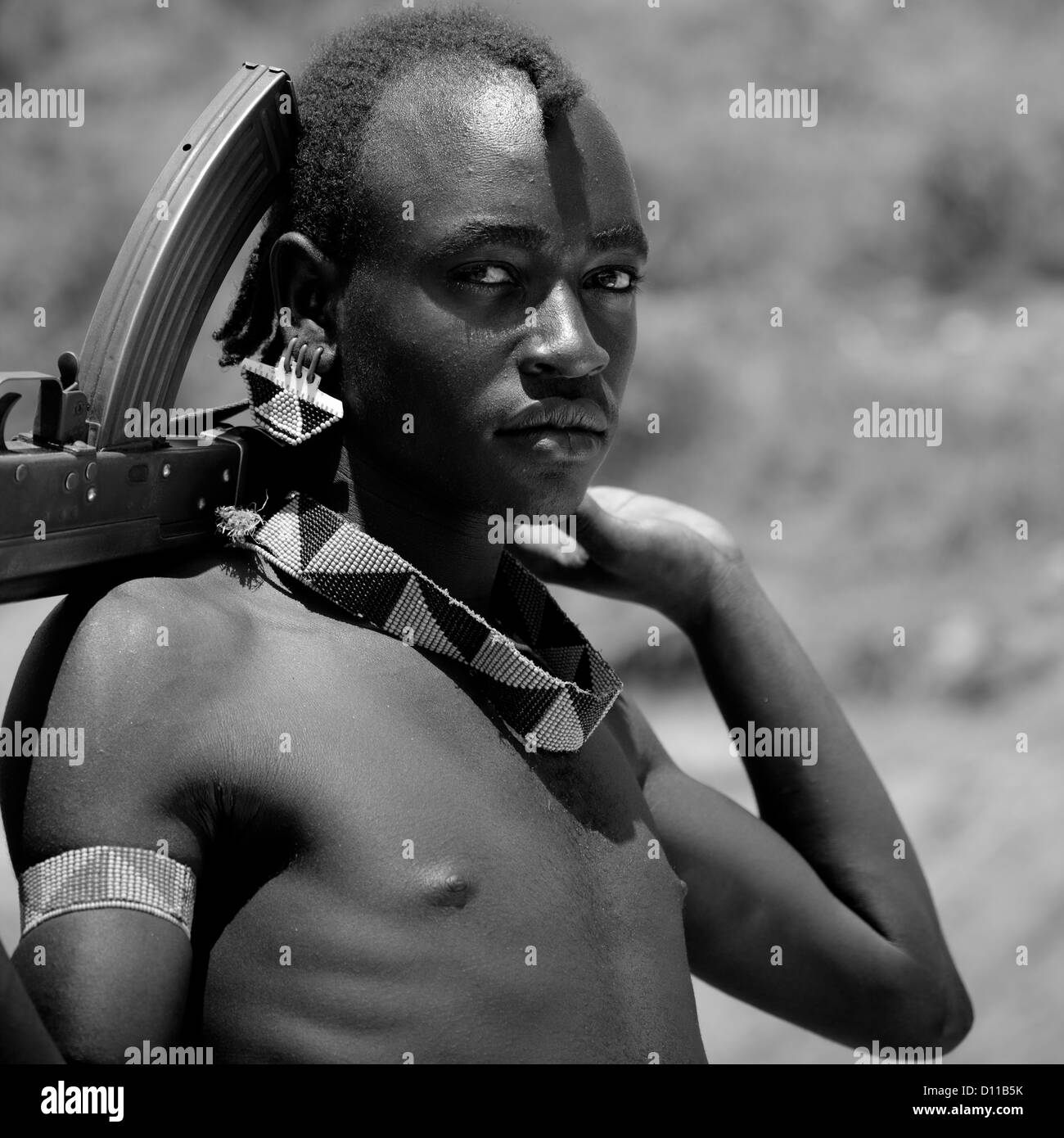 Ritratto in bianco e nero di una banna tribù Guerriero con kalashnikov, Valle dell'Omo, Etiopia Foto Stock