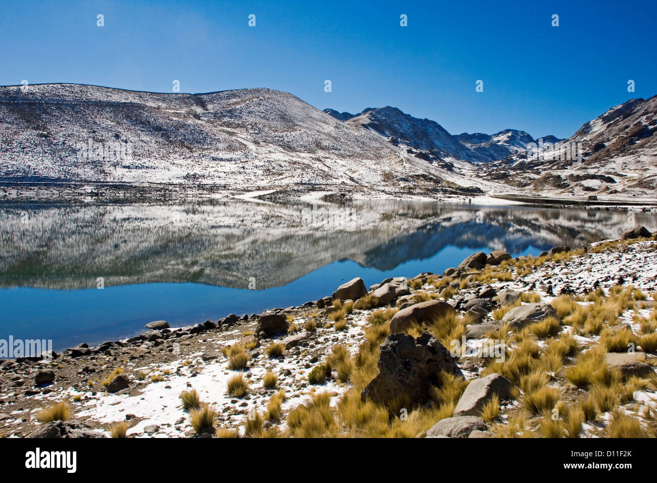 Paesaggio boliviano con montagne coperte di neve e calme acque azzurre della laguna di San Sebastian nei pressi di Potosí, montagne delle Ande, Foto Stock