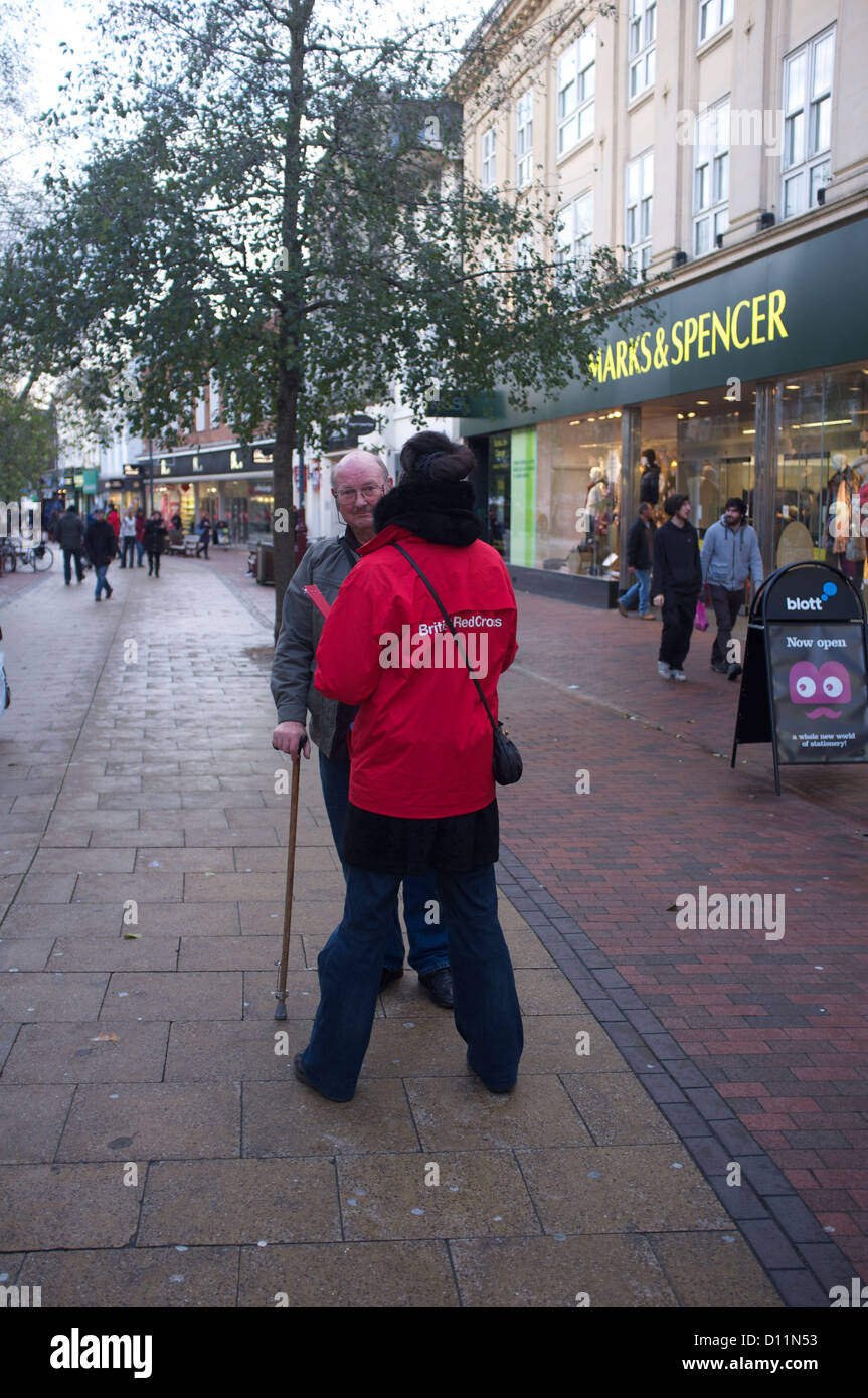 La carità street lavoratore parlando di un uomo in un quartiere dello shopping. Noto con il soprannome di chuggers Foto Stock
