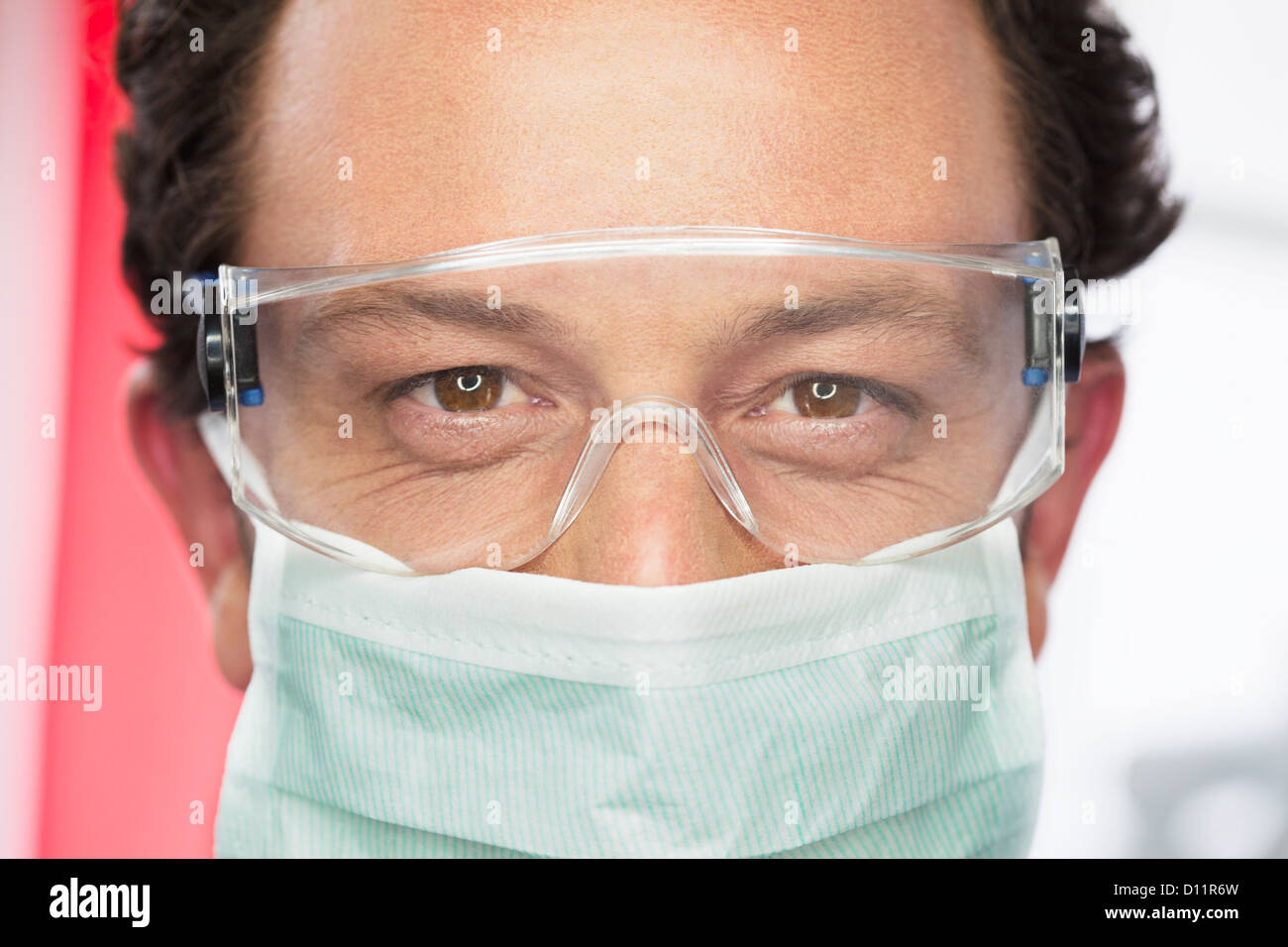Germania, dentista con gli occhiali di sicurezza e la mascherina chirurgica in studio dentistico Foto Stock