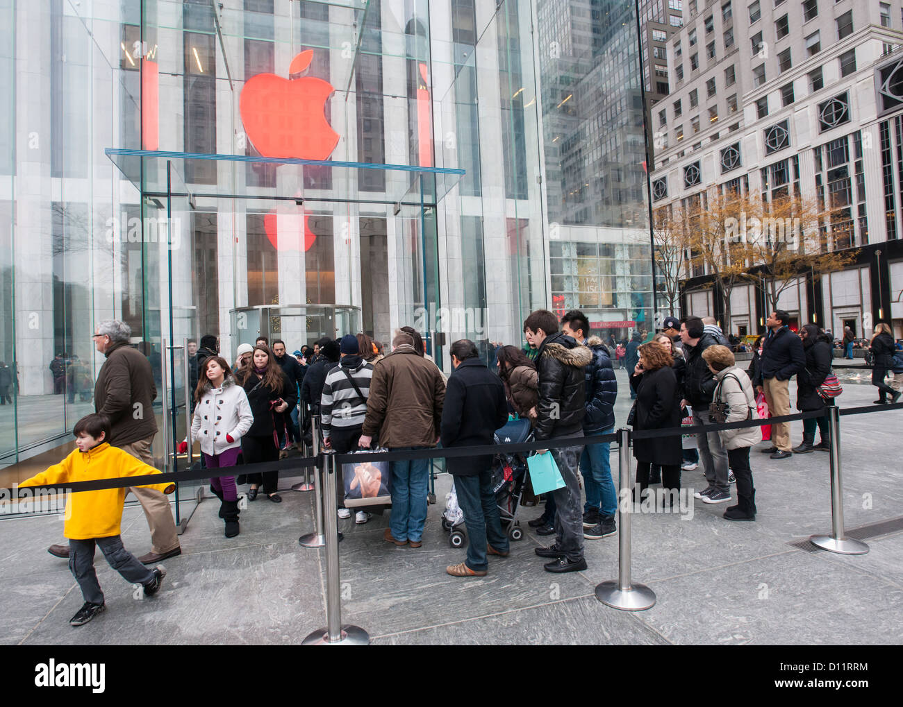 Gli amanti dello shopping line fino a inserire l'Apple Store, con il logo Apple colorato di rosso sulla Fifth Avenue a New York Foto Stock