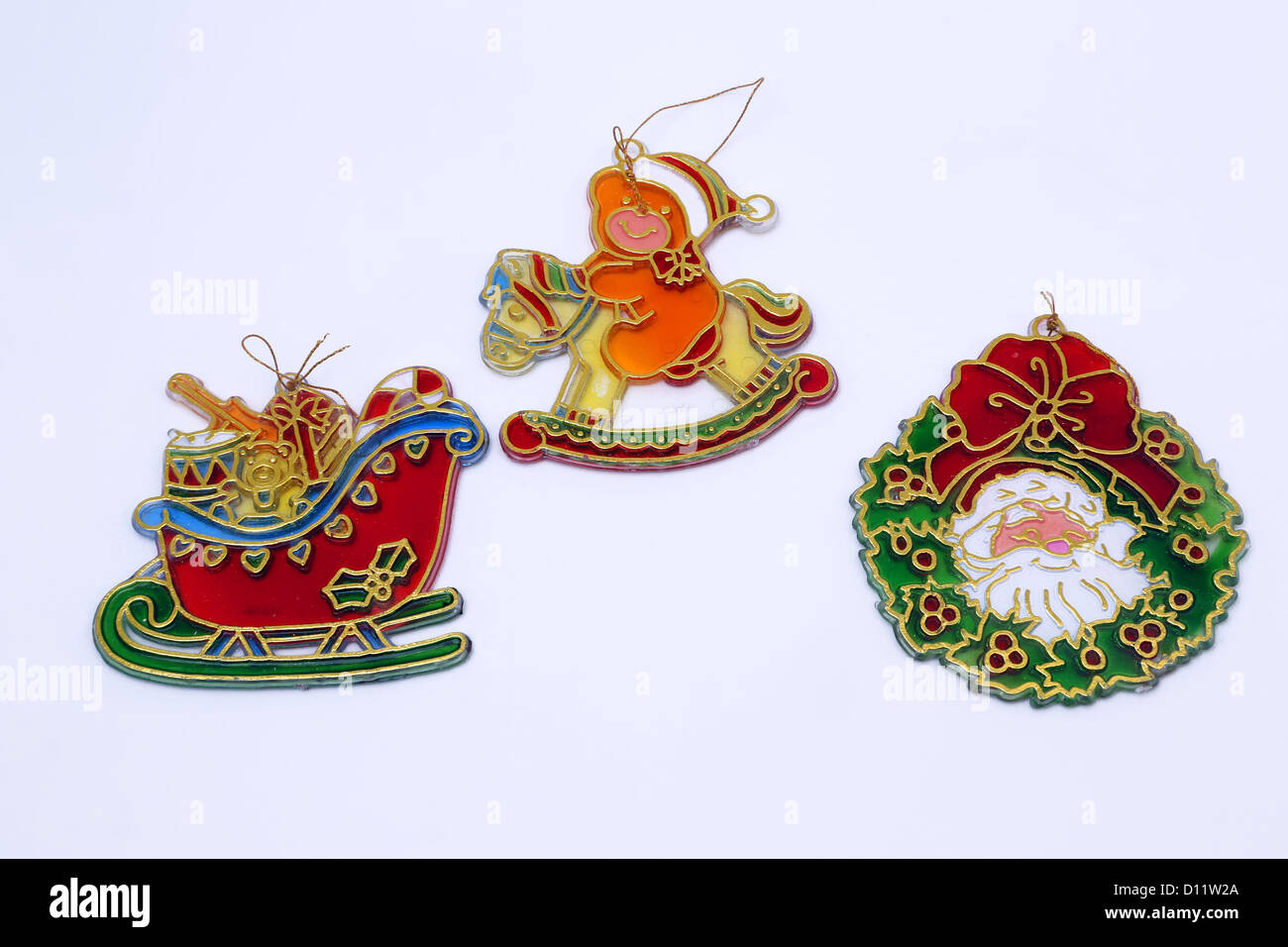 Suncatchers decorazioni natalizie Babbo Natale con la slitta presenta, Orsacchiotto sul cavallo a dondolo e Santa in una ghirlanda di Natale Foto Stock