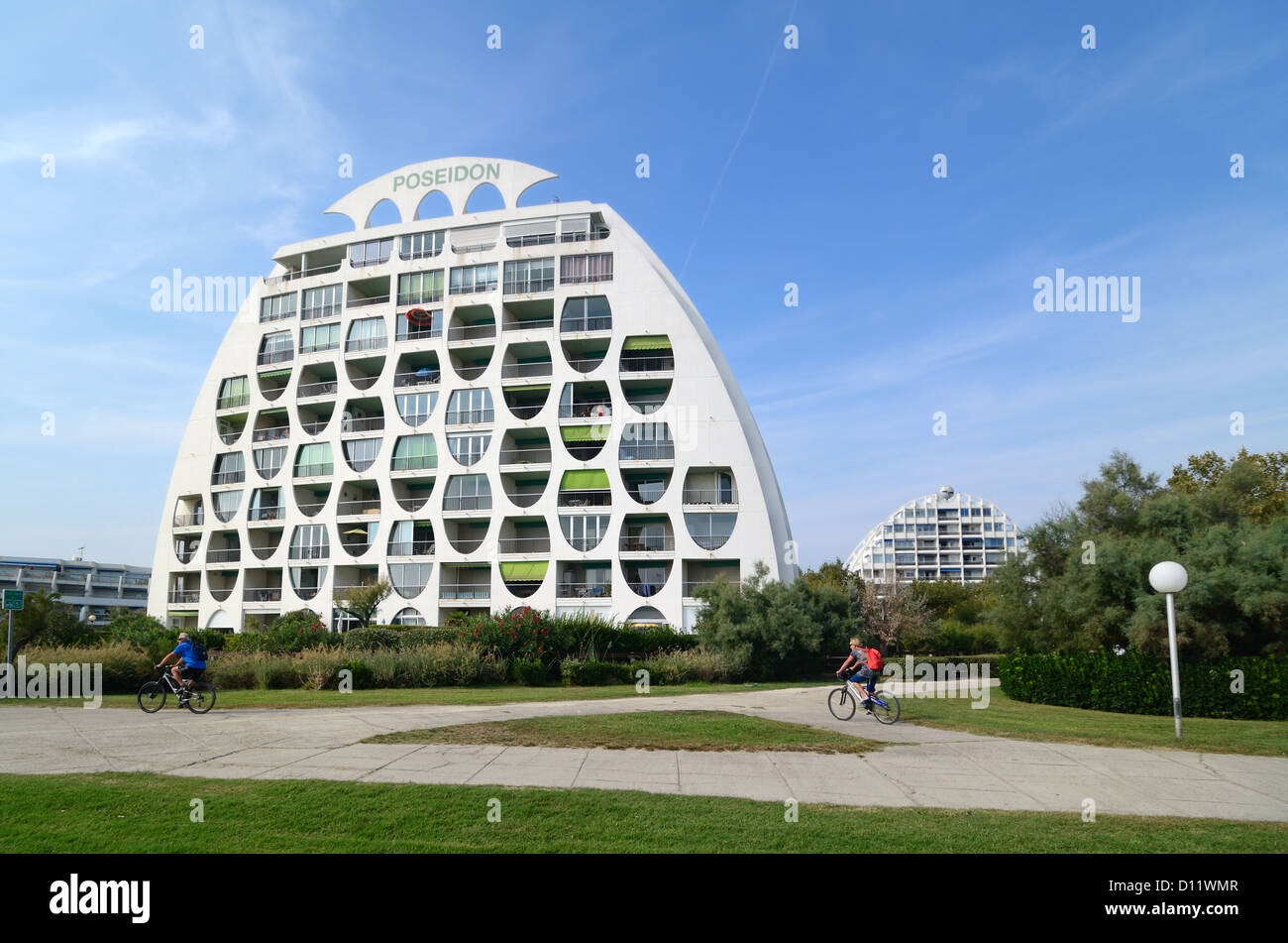 Turisti in bicicletta passato il Poseidon Modernista (1981) Appartamenti per vacanze di Gilles Balladur a la Grande-Motte Holiday Resort Town Hérault France Foto Stock