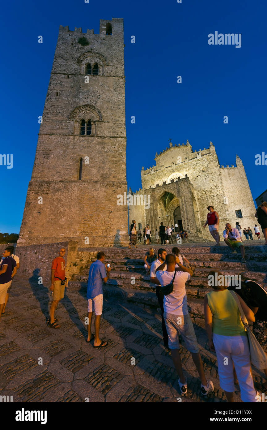 I turisti di fronte alla torre campanaria e la cattedrale di Erice, provincia di Trapani, Sicilia, Italia Foto Stock