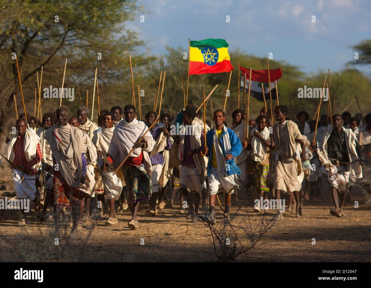 Gruppo di tribù Karrayyu uomini a piedi con il Oromo e bandiere etiope, Gadaaa cerimonia, Metahara, Etiopia Foto Stock