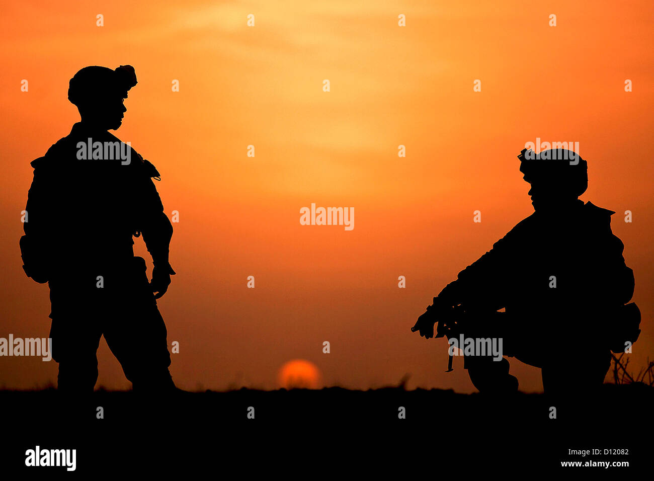 Marines americani posizionarsi in corrispondenza di una posizione difensiva come il sole tramonta 11 febbraio 2012 nel deserto Registan, provincia di Helmand, Afghanistan. Foto Stock