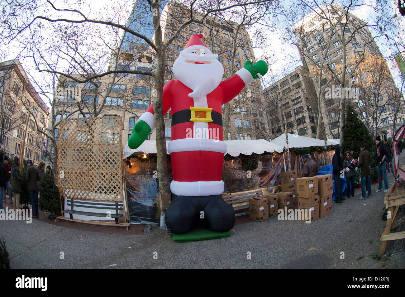 Un gigante gonfiato Santa Claus presiede un stand con vendita di alberi di Natale nel quartiere di Soho di New York Foto Stock
