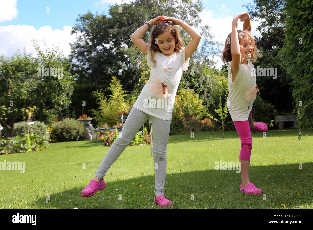 Sorelle indossando la stessa Ballerina T-Shirt e Dancing in the Garden Surrey in Inghilterra Foto Stock