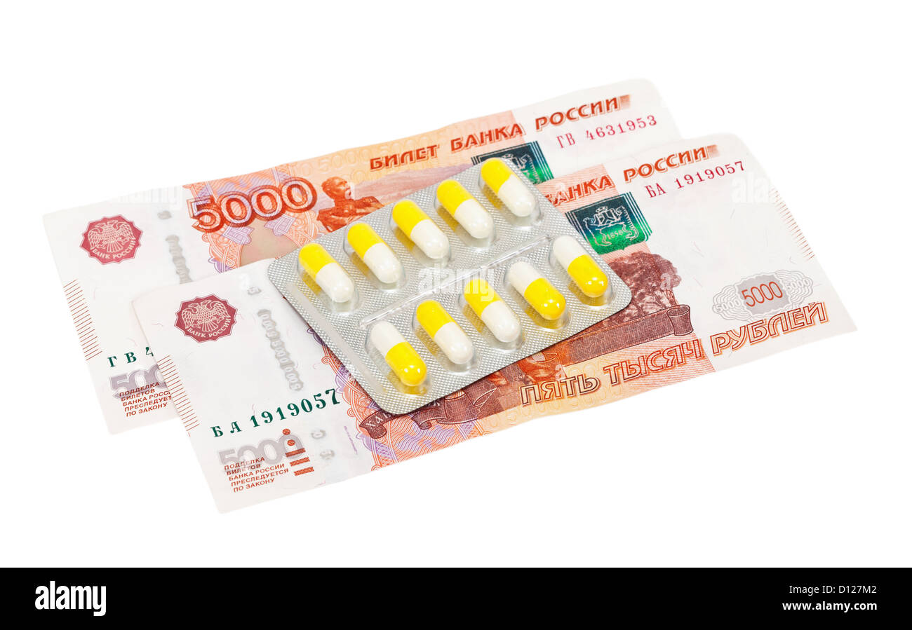 Pillole e denaro su sfondo bianco Foto Stock