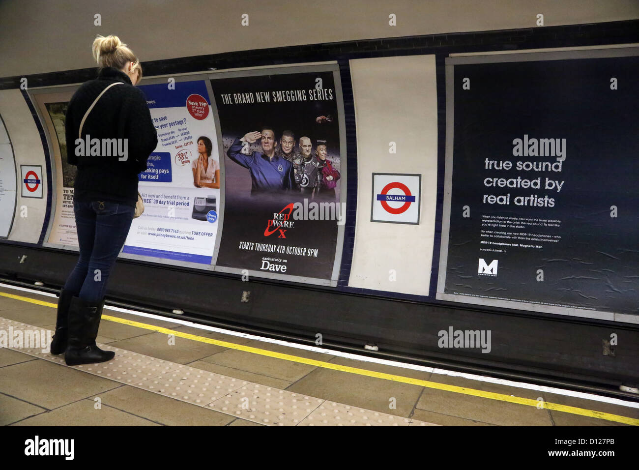 Londra Inghilterra donna in attesa sulla piattaforma a Balham Stazione della Metropolitana Foto Stock