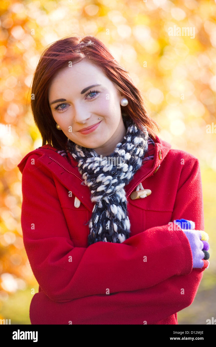 Ritratto di una giovane donna che indossa un rosso duffel coat in autunno scozzese. Foto Stock