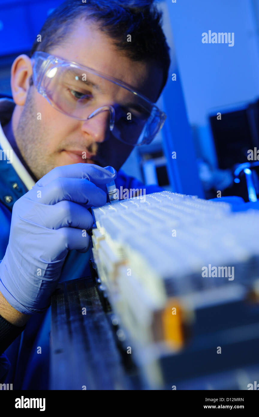 Scienziato esamina micro tubi di prova pronto per l'immissione in una centrifuga nel laboratorio di scienze Foto Stock