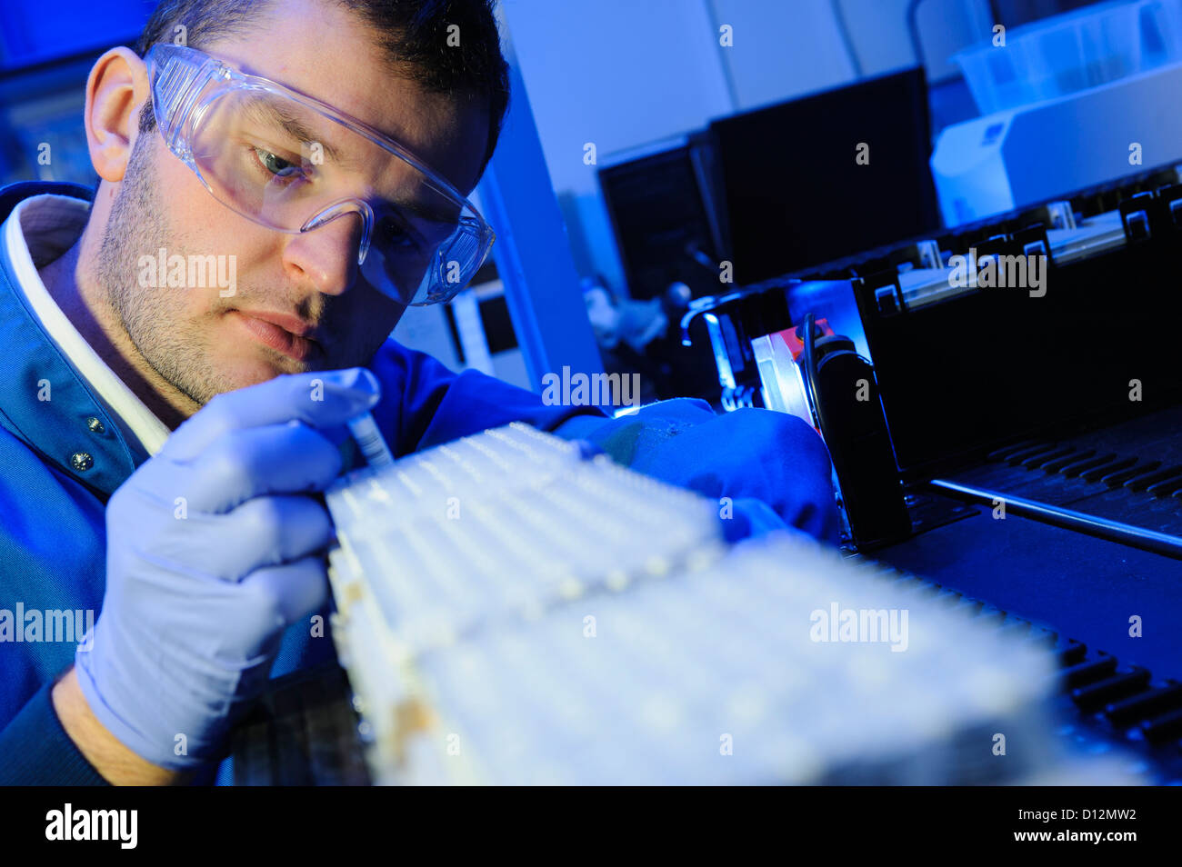 Scienziato esamina micro tubi di prova pronto per l'immissione in una centrifuga nel laboratorio di scienze Foto Stock