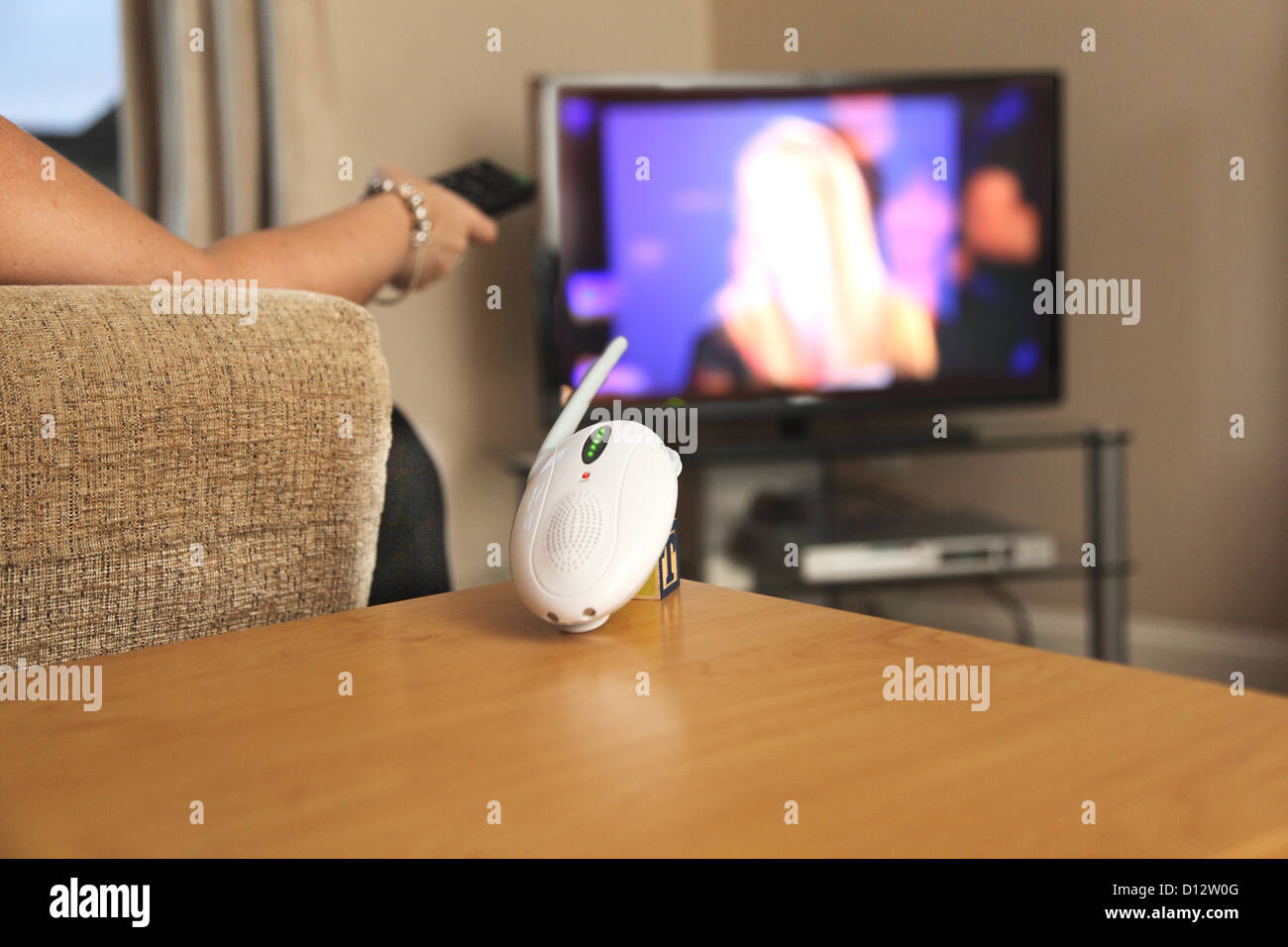 Una donna che guarda la televisione e ignora un bambino allarme. Foto Stock