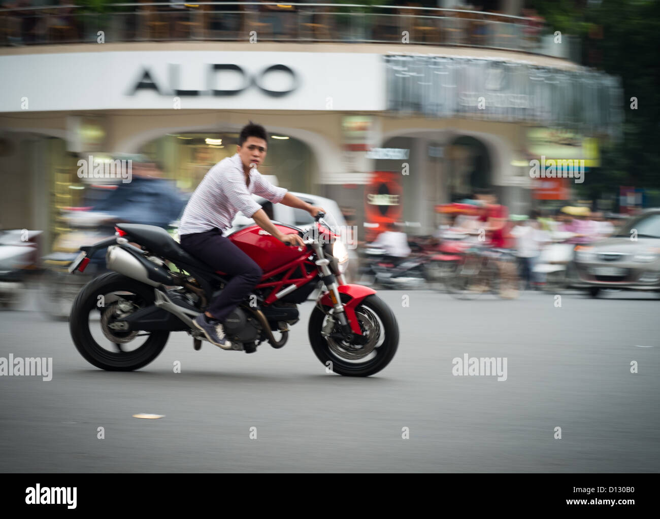 Young Asia maschio su moto senza casco durante le ore di punta in Hanoi Vietnam del Sud-est asiatico Foto Stock