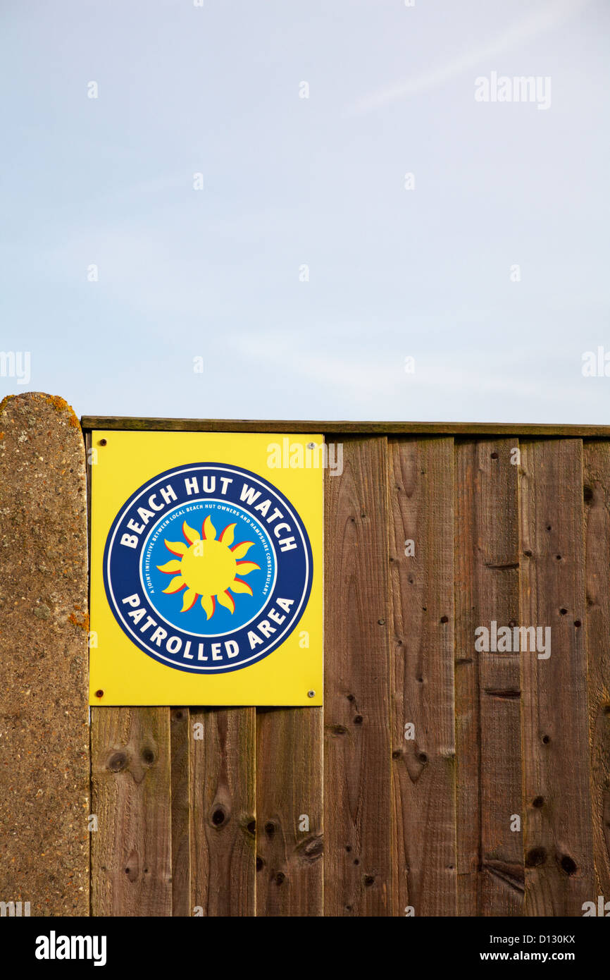 Beach Hut guardare area sorvegliata per il segno a Calshot, Hampshire nel novembre Foto Stock